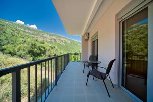 a balcony with a table and chairs and a hill at Trsteno Beach Apartments in Budva