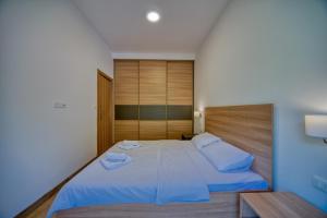 a bedroom with a large bed with blue sheets at Trsteno Beach Apartments in Budva +37 photos