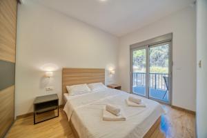 a bedroom with a large bed with two towels on it at Trsteno Beach Apartments in Budva