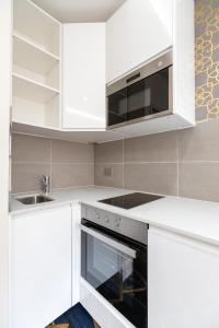 a white kitchen with a sink and a microwave at Marble Arch Mews Apart'hotel in London