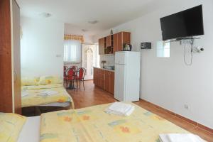 een kamer met een keuken met een koelkast en een tafel bij Apartmani Vila Caska in Novalja