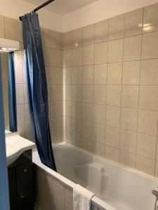 a bathroom with a bath tub with a shower curtain at Disney, comfortable 2 bedrooms family apartment, 7 pers, wifi, NETFLIX in Chessy +51 photos