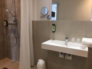 a bathroom with a sink and a shower at SleepySleepy Hotel Dillingen in Dillingen an der Donau