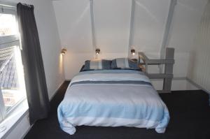 En eller flere senge i et værelse på Knus vertoeven in een historisch pand in Grou.