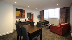 um quarto de hotel com uma área de refeições, uma mesa e cadeiras em Holiday Inn Huntingdon Racecourse, an IHG Hotel em Huntingdon