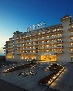 a large hotel building with lights in a courtyard at Steigenberger Hotel El Lessan in Ras El Bar