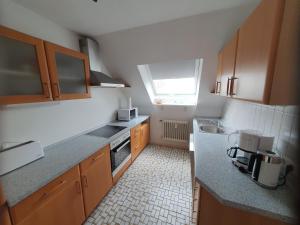 a small kitchen with wooden cabinets and a window at Ferienwohnung Deichblick 2 in Gerhardshofen