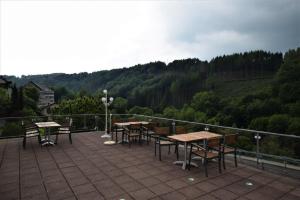 a patio with tables and chairs on top of a hill at Hotel Eifeler Hof Kyllburg in Kyllburg