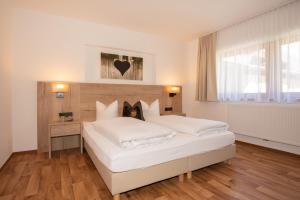 a bedroom with two white beds in a room at Haus Elisabeth in Sankt Leonhard im Pitztal