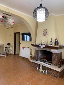 a living room with a brick fireplace and a television at B&B Al San Francesco in Castel di Sangro