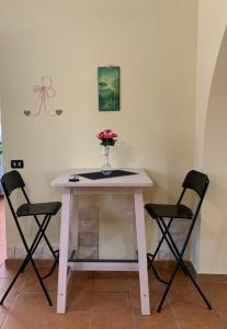 桑格羅堡的住宿－B&B Al San Francesco，一张桌子,两把椅子,花瓶上放着鲜花