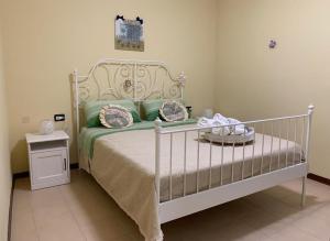 a bedroom with a bed with green and pink pillows at B&B Al San Francesco in Castel di Sangro