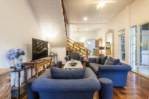 a living room with blue couches and a tv at Villa Alexandra Seminyak in Kerobokan