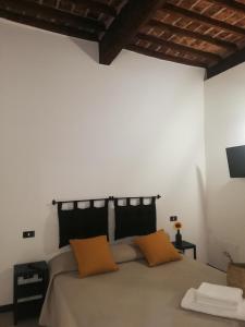 een slaapkamer met een bed met 2 oranje kussens bij A du passi Affittacamere in Città di Castello