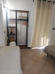 een slaapkamer met een bed en een raam met gordijnen bij A du passi Affittacamere in Città di Castello