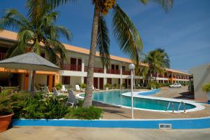 Aruba Quality Apartments & Suites في شاطئ بالم إيغل: منتجع فيه مسبح والنخيل