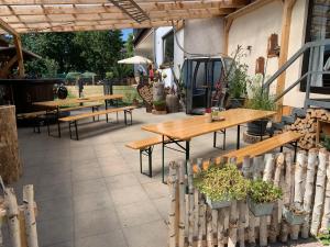 eine Terrasse mit Holztischen, Bänken und Pflanzen in der Unterkunft Kubacher Hof in Kubach