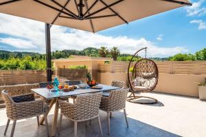 patio con tavolo, sedie e ombrellone di Luxury Villa Matzourana by PosarelliVillas a Gardeládes