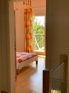 Mont-sur-RolleにあるChambre D'Hôtes Wellingtoniaのベッドルーム1室(ベッド1台付)、窓、バルコニーが備わります。