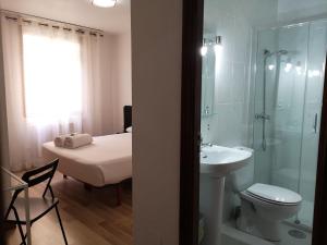a bathroom with a toilet, sink, and shower at Pensión Las Rías in A Coruña