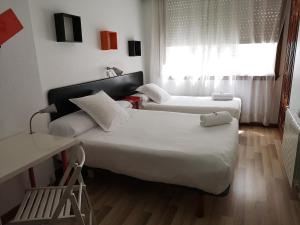 ein Hotelzimmer mit 2 Betten und einem Fenster in der Unterkunft Pensión Las Rías in A Coruña