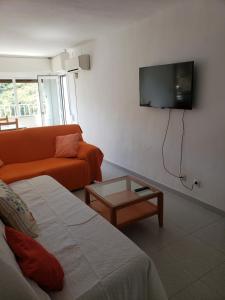 uma sala de estar com um sofá e uma televisão na parede em Apart.3 habit.mar-mont. AC-Terraza-ascensor-parking em Calella
