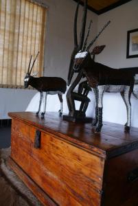 two reindeer statues sitting on top of a wooden chest at Zwartberg View Mountain Lodge in Oudtshoorn