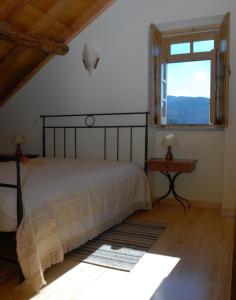 a bedroom with a large bed and a window at Casa da Moreia in Sabugueiro