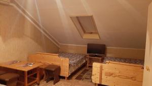 a room with two beds and a table and a tv at Mishel House in Lazarevskoye