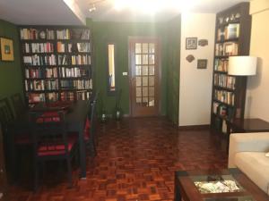 een woonkamer met een bank en boekenplanken bij Fontevella in Porriño