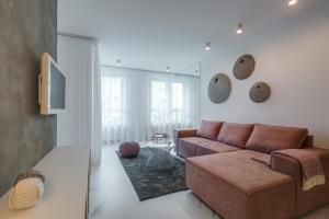 a living room with a couch and a tv at CHILLIapartamenty - Platany - POWDER in Kołobrzeg