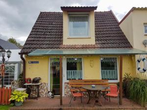 a yellow house with a table and chairs in front of it at Ferienwohnungen in Semlow in Semlow +20 photos