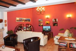 a living room with red walls and white furniture at El Corral de Valero in Valdealgorfa