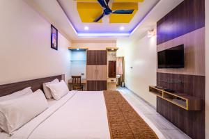 a hotel room with a bed and a flat screen tv at Thaneegai Residency in Puducherry