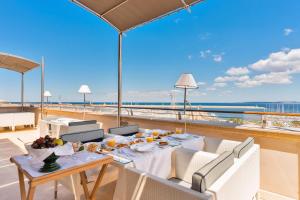 a dining table on a balcony with a view of the ocean at Palazzo del Corso – Boutique Hotel in Gallipoli