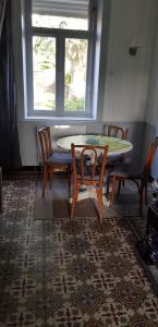 d'une salle à manger avec une table, des chaises et une fenêtre. dans l'établissement Cosy Cottage, à Beugin