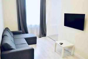 a living room with a couch and a tv at White&Light flat near Gulliver in Kyiv