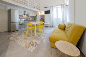 un salon avec un canapé jaune et une cuisine dans l'établissement La Nghioscia, à Grottaglie