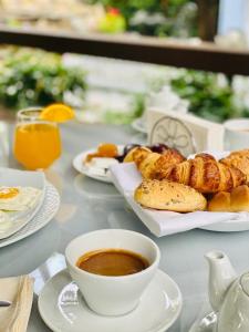 a table with plates of food and a cup of coffee at Hotel Boavista in Timişoara