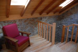 een zolderkamer met een stoel en 2 trappen bij Casa da Moreia in Sabugueiro