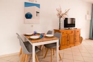 - une salle à manger avec une table, des chaises et une télévision dans l'établissement Kallao Apartment, à Puerto del Carmen