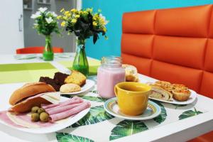 a table with plates of food and a cup of juice at Hotel Aeroporto Montese Star in Fortaleza