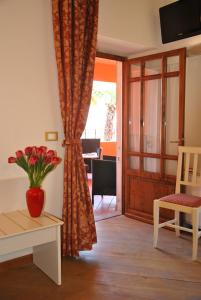un soggiorno con un vaso di fiori su un tavolo di Hotel Villa San Michele a Carmignano