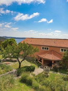 a house with a red roof and a tree at Apartmani Ana in Mlini