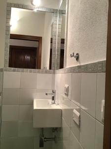 a white bathroom with a sink and a mirror at La Cuppulata in Budoni +40 photos