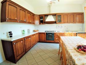 a kitchen with wooden cabinets and a table in it at Agriturismo Barbarino in Vinci