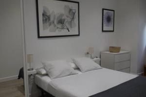 een slaapkamer met een wit bed en een foto aan de muur bij Donostia, a pocos pasos de la playa de la Concha. in San Sebastian