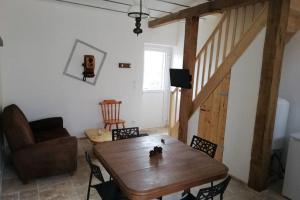 a living room with a wooden table and a couch at La maison du colombophile in Neuville-sur-Ailette