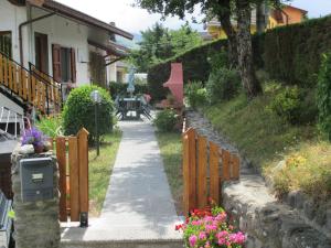 a walkway next to a house with a fence at Appartamento il Bosco in Pievepelago