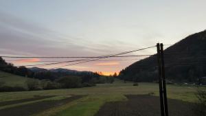 una vista de un campo con una puesta de sol en el fondo en Guest house Jana, en Muráň